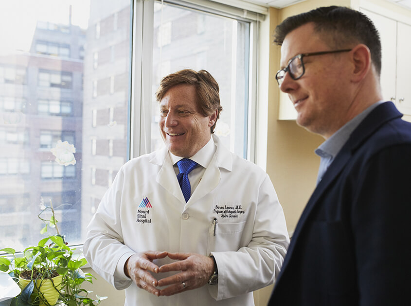 A physician and an administrator reviewing billing and payment reports together